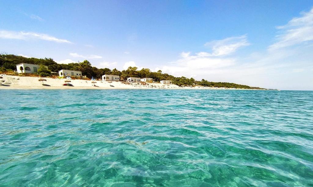 uitzicht op een strand vanaf het water bij Camping Naturiste Riva Bella 4* in Linguizzetta