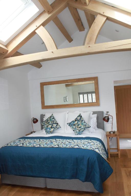 ein Schlafzimmer mit einem großen Bett und einem großen Spiegel in der Unterkunft Bryher Cottage in Paul