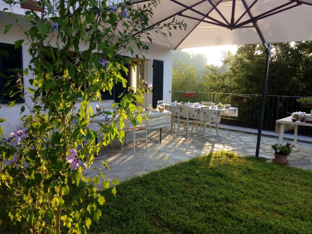 une terrasse avec une table et des chaises sous un parasol dans l'établissement Cascina Spazio Indaco, à Castagnole Monferrato