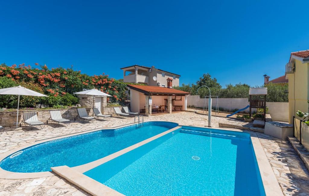 a swimming pool in a yard next to a house at Casa Olivia in Kaštelir