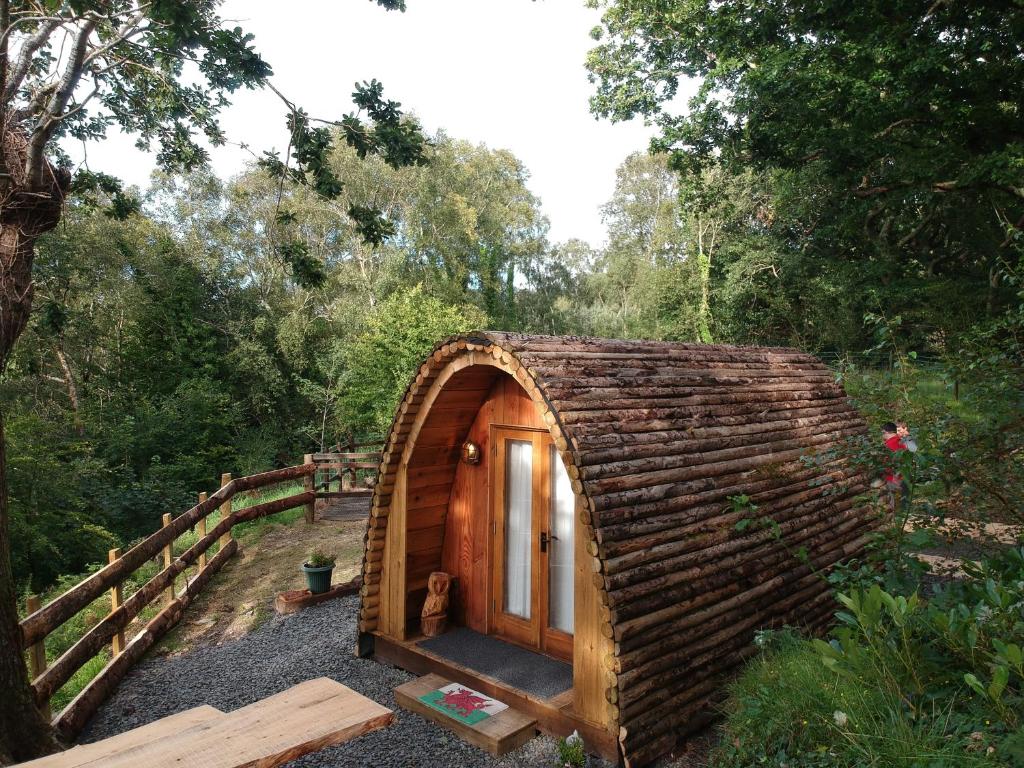 a small wooden cabin in the middle of a forest at Owl Hut Cosy Ensuite Pod Snowdonia Coast Sleeps 2 in Dolgellau