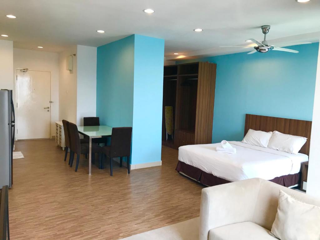 Una habitación de hotel con una cama, una mesa y sillas. en Mansion One Suites by Little Cabin, en George Town