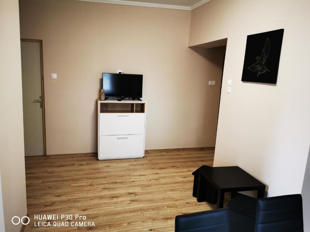 una sala de estar con TV en una cómoda blanca con un tvictericter en Renáta Apartman, en Siófok