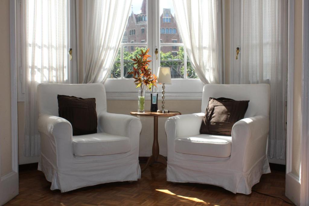 2 weiße Stühle in einem Zimmer mit Fenster in der Unterkunft Ally's Bed&Breakfast, in Barcelona