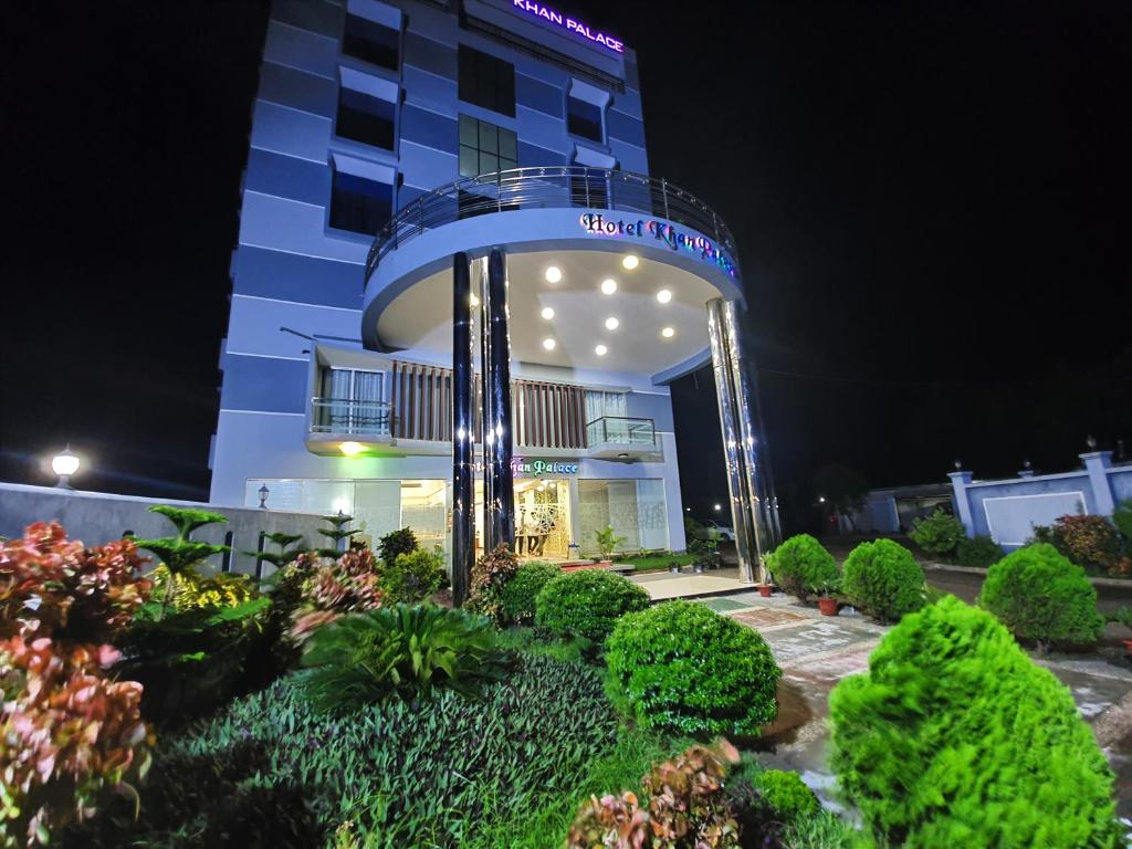 Hotel Khan Palace في كواكاتا: فندق بالليل وامامه حديقه