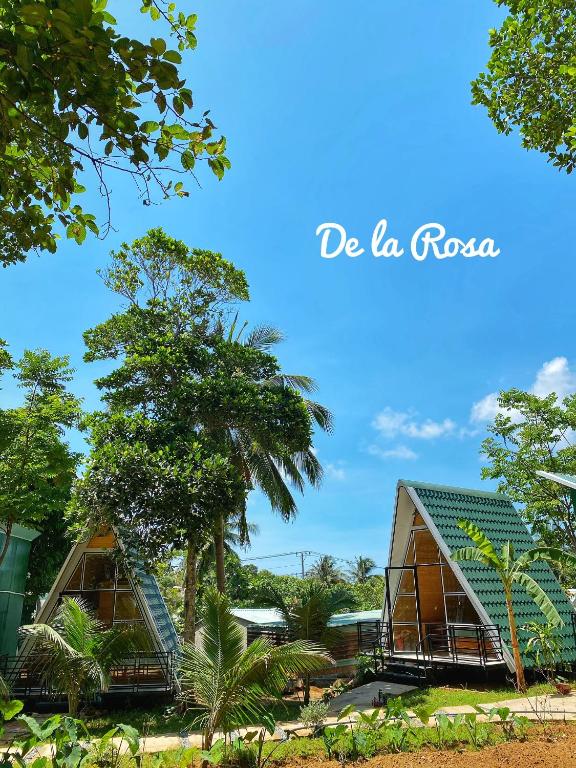 a view of two houses with trees in the background at Homestay De la Rosa - Côn Đảo in Con Dao