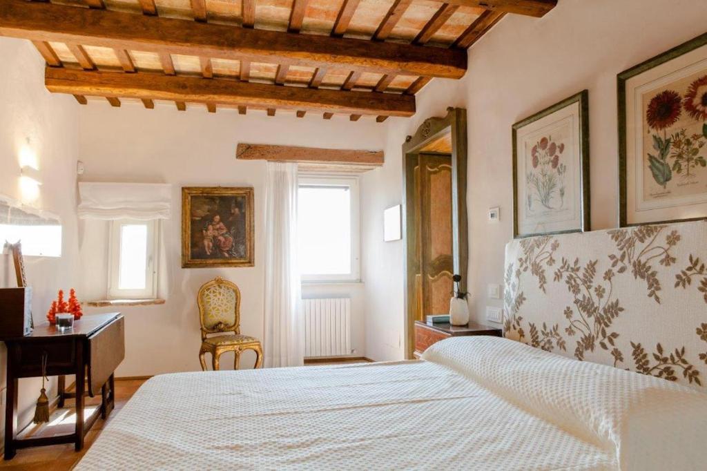 sypialnia z białym łóżkiem i biurkiem w obiekcie MarcheAmore - Torre da Bora, Luxury Medieval Tower w mieście Magliano di Tenna