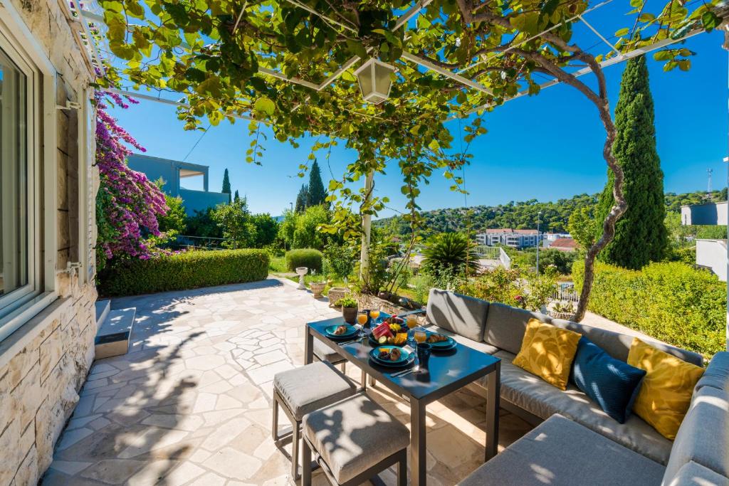 eine Terrasse mit einem Sofa und einem Tisch mit Essen drauf in der Unterkunft Ellanna in Mlini