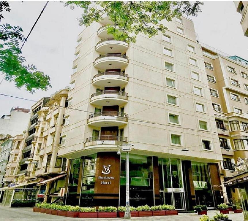 a large white building with balconies on a street at SV Bussiness Hotel Taksim in Istanbul