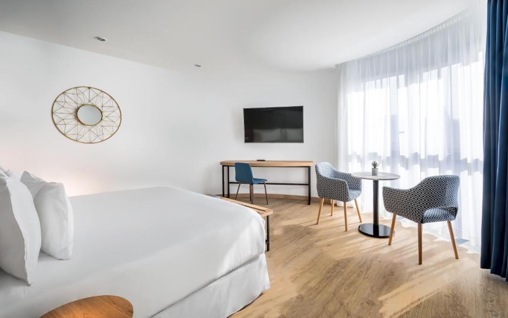 a hotel room with a bed and a table and chairs at Barceló Costa Vasca in San Sebastián