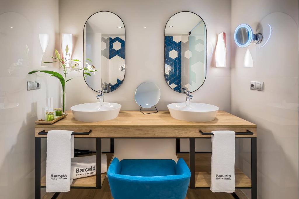 a bathroom with two sinks and two mirrors at Barceló Costa Vasca in San Sebastián