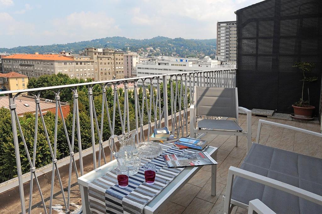 - un balcon avec une table et des verres à vin dans l'établissement Appartamento con vista in zona Lingotto by Wonderful Italy, à Turin