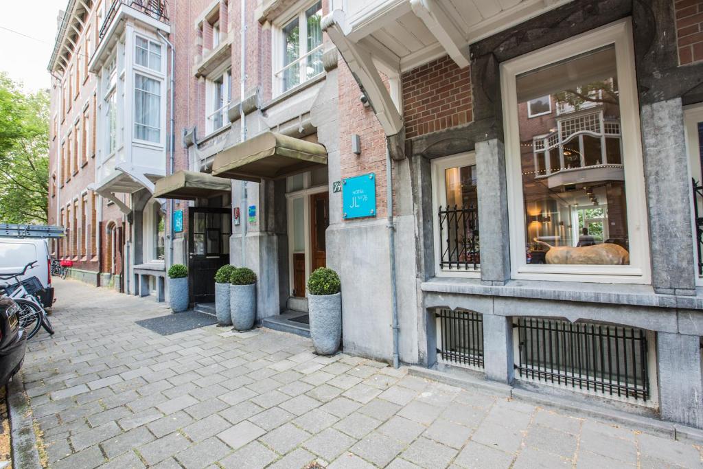 une rue urbaine avec des bâtiments et un trottoir avec un magasin dans l'établissement Hotel JL No76, à Amsterdam