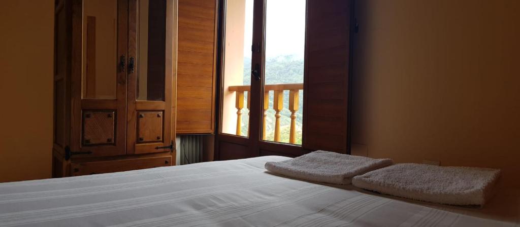 1 dormitorio con 1 cama y 2 toallas blancas en El llagar, en Vis