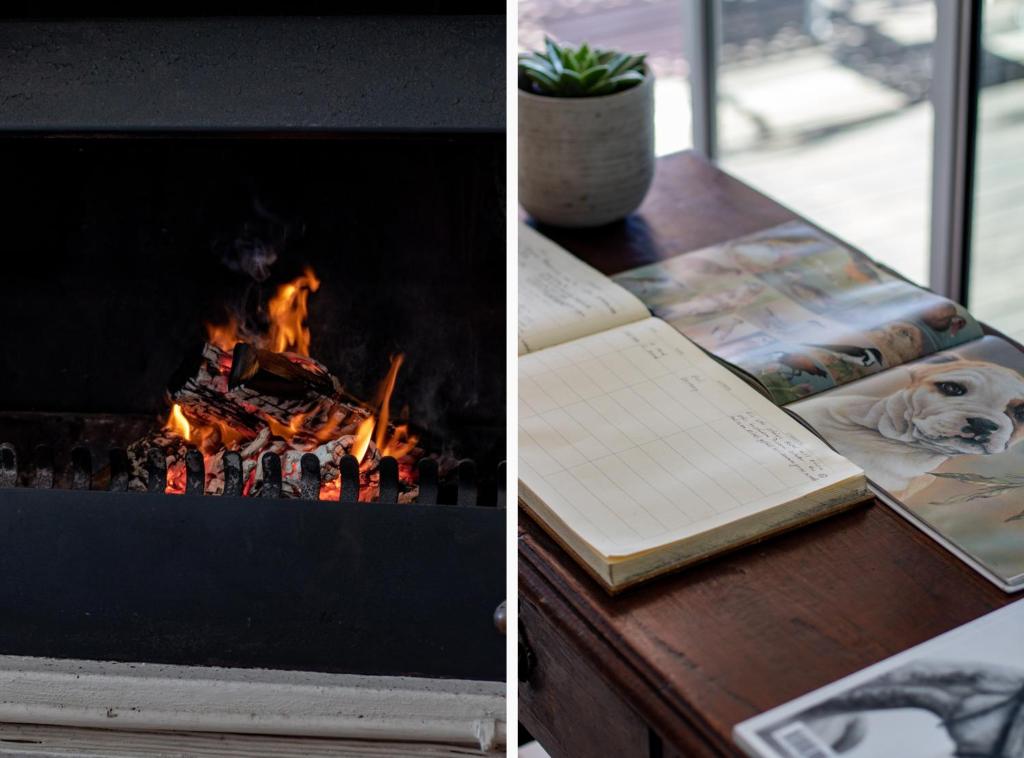 a book sitting on a table next to a fireplace at Blaauw Village Guest House in Bloubergstrand