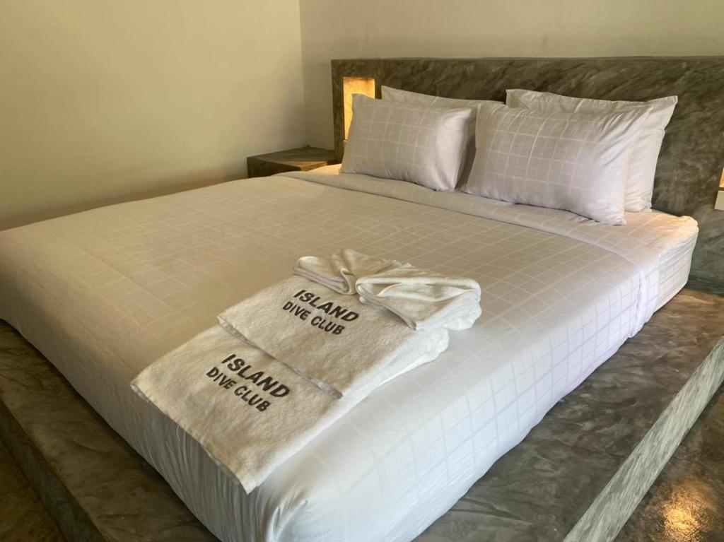 a bed with two towels on top of it at Island Dive Club in Koh Tao