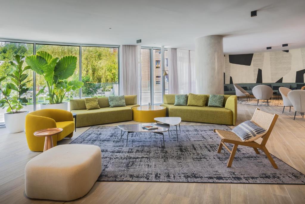 a living room with yellow and green furniture at Barceló Costa Vasca in San Sebastián