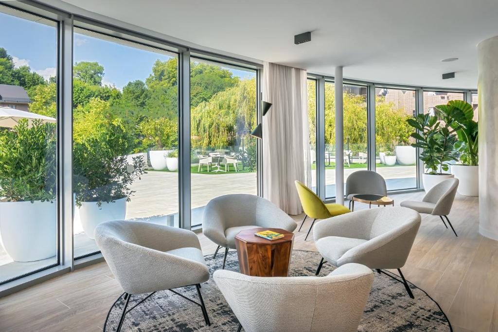 a room with chairs and tables and large windows at Barceló Costa Vasca in San Sebastián