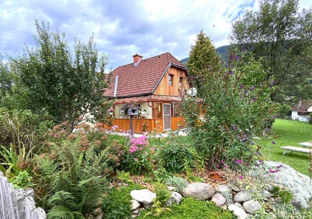 una casa de madera con un jardín delante de ella en CHALET DORFER, en Sankt Lorenzen ob Murau