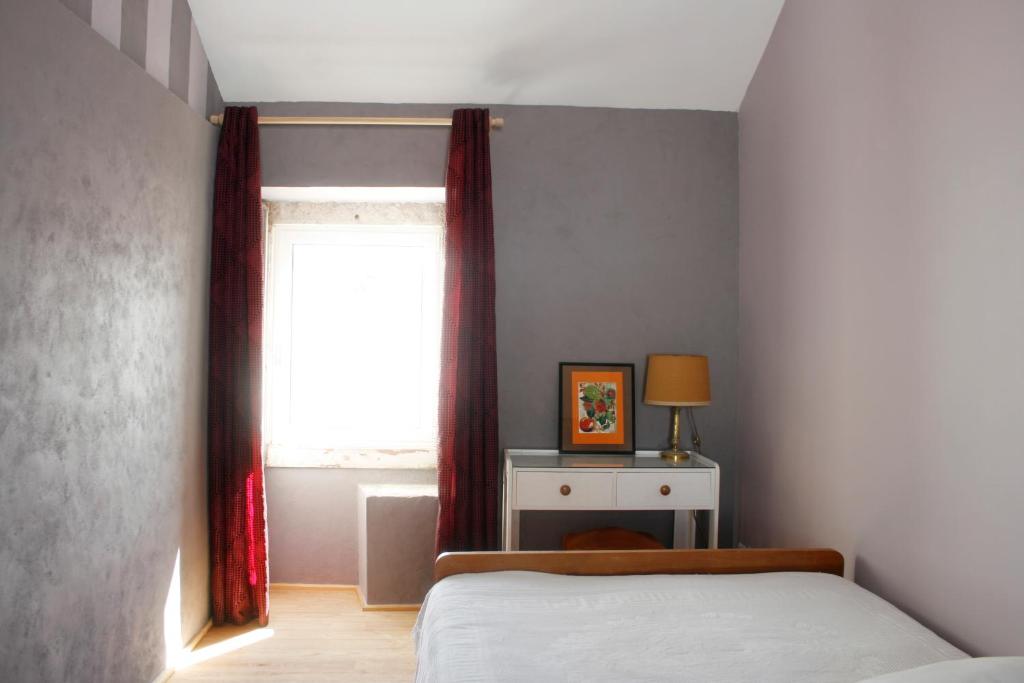 a bedroom with a bed and a window at Sonho do Poeta in Sintra