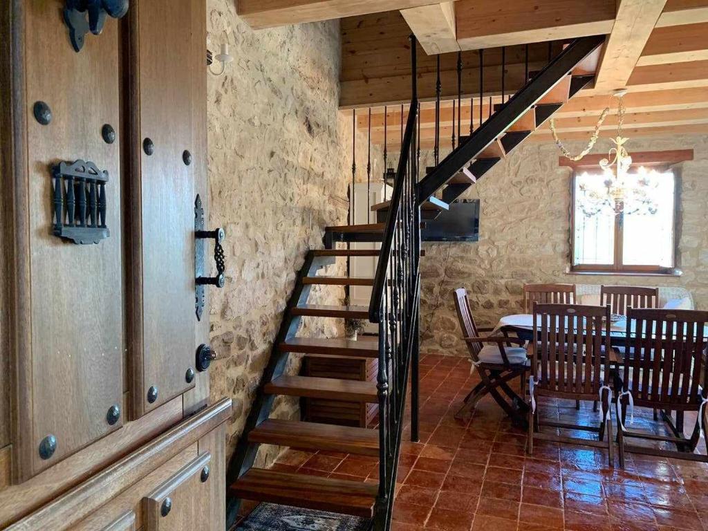 uma escada num quarto com uma mesa e uma sala de jantar em Casa Rural El Pajarcillo em Moriana