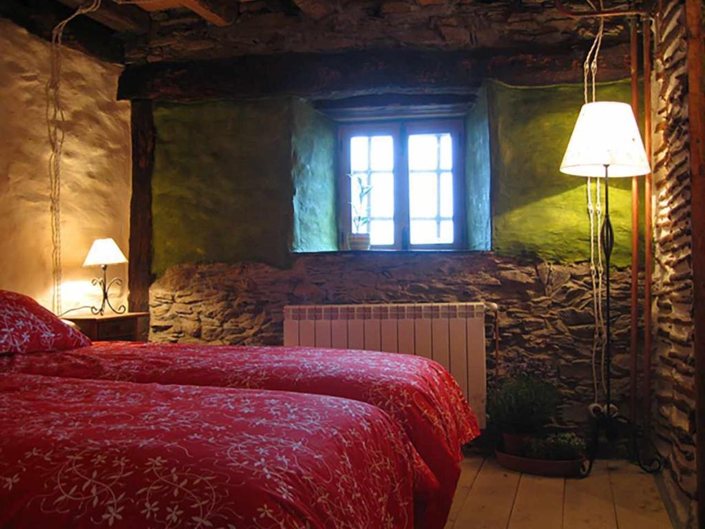 ein Schlafzimmer mit einem roten Bett und einem Fenster in der Unterkunft Casa Rural Sobre Fábulas in Prádena de Atienza