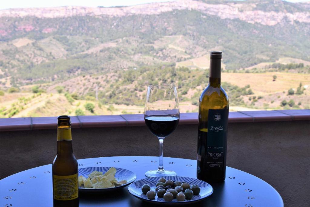 uma mesa com uma garrafa de vinho e um copo em Ca lAixut Turismo Rural em Gratallops