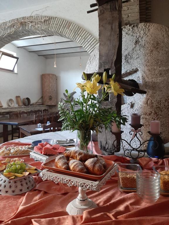 uma mesa com um prato de pão e flores em LAE' affittacamere em Roccamontepiano