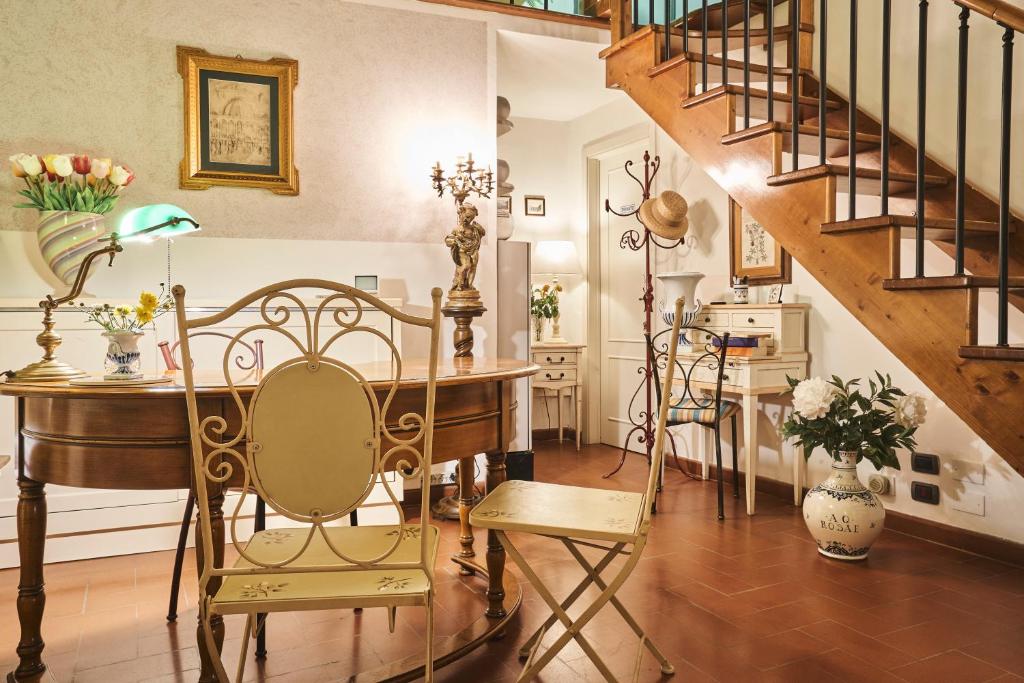 een kamer met een tafel en stoelen en een trap bij Locanda De' Ciompi in Florence