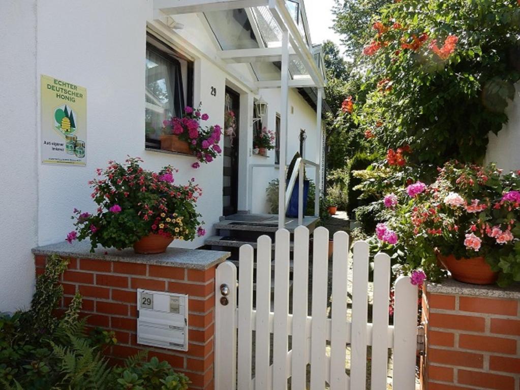 een wit houten hek voor een huis met bloemen bij Ferienwohnung Günther in Lauf an der Pegnitz