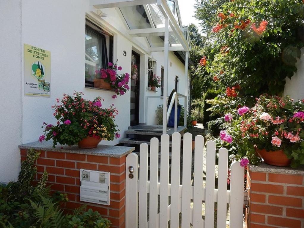 a white picket fence in front of a house with flowers at Ferienwohnung Günther in Lauf an der Pegnitz