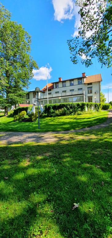 a large building in the middle of a grass field at Kisa Wärdshus & Hotell in Kisa