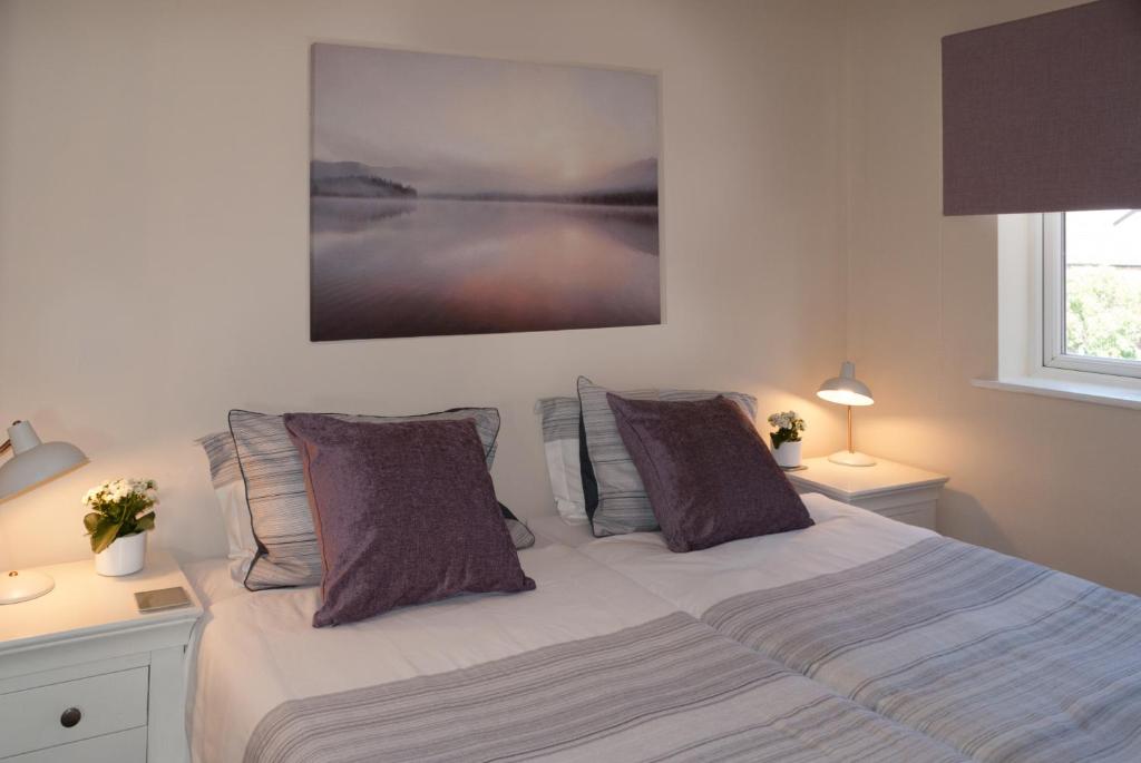 a bedroom with a bed with purple pillows at Chestnut Court 2 Bed Apartment FREE Parking WiiFi Smart TV in Wellingborough