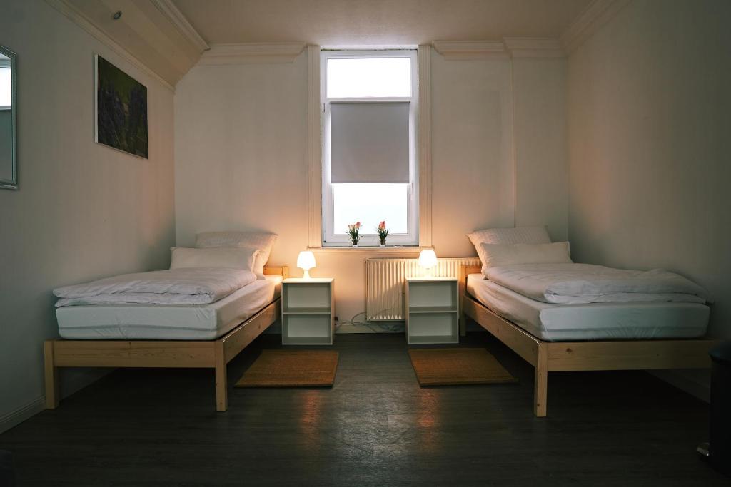 2 Betten in einem Zimmer mit Fenster in der Unterkunft Pension Burglesum Bremen in Bremen