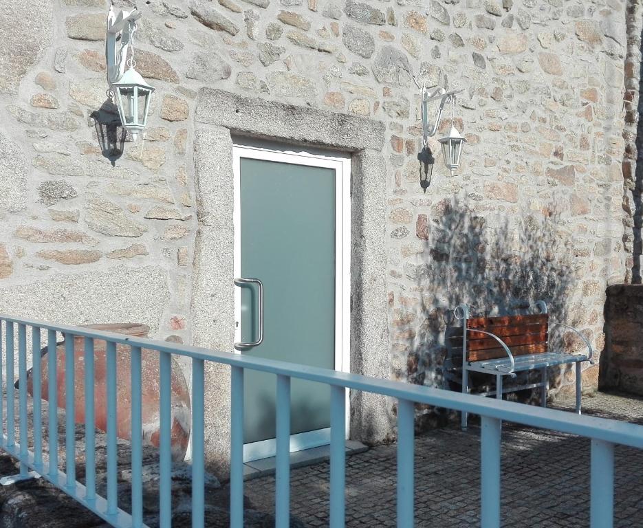 uma porta num edifício de pedra com um corrimão azul em Casa do Vale da Mula em Almeida