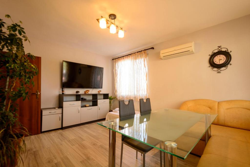 een woonkamer met een glazen tafel en een bank bij Apartment Yanevi in Lozenets