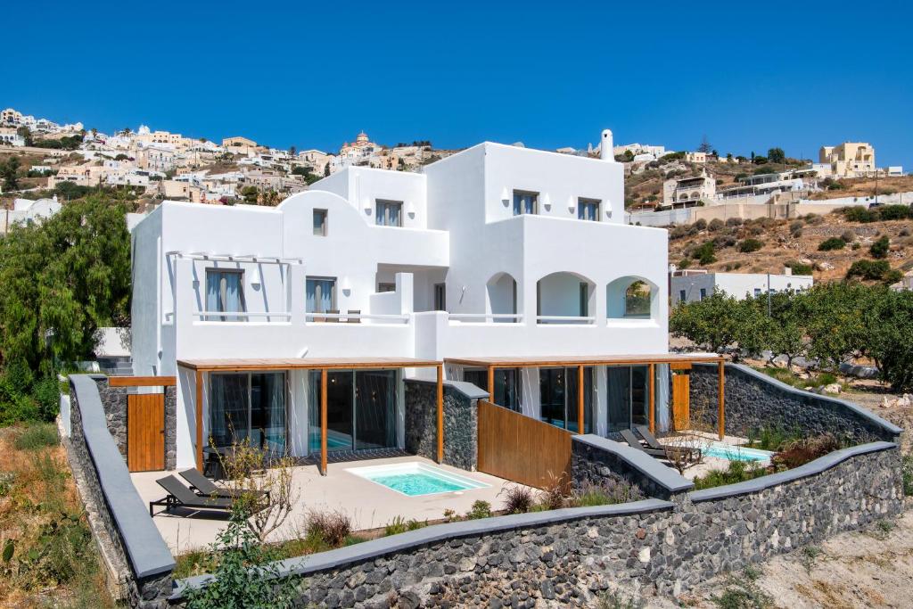 une maison blanche sur une colline avec vue dans l'établissement Gonia Residences, à Pyrgos