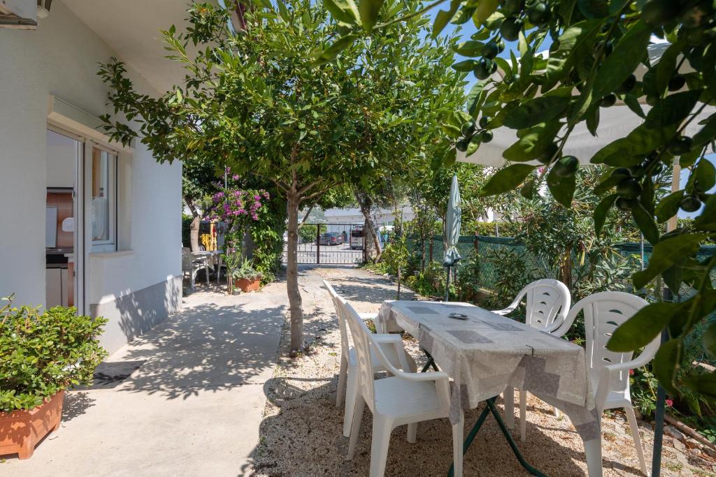une table et des chaises assises sous un arbre dans l'établissement Apartments near beach Babic, à Split