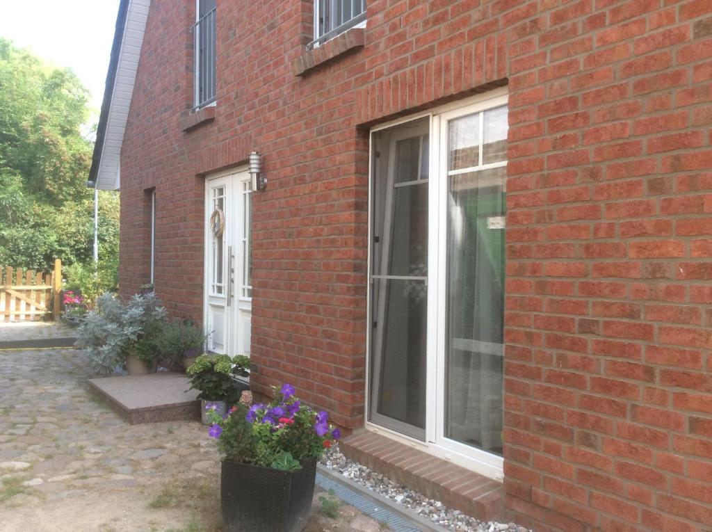 a brick house with a window and purple flowers at Auszeit am Haffufer in Wilhelmshof