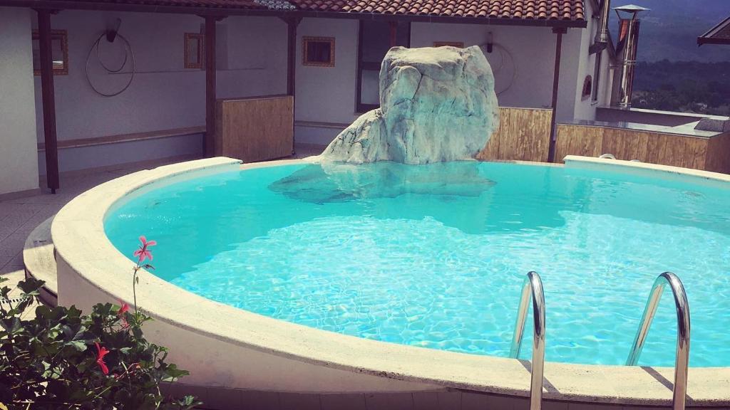 uma piscina com uma fonte no meio em Hotel PINO LORICATO em Castelluccio Inferiore