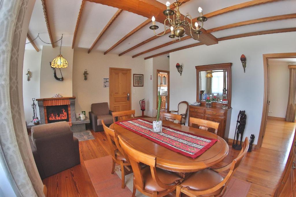 a dining room with a table and chairs and a fireplace at Apartamentos Francisco Martins in Vila Franca do Campo