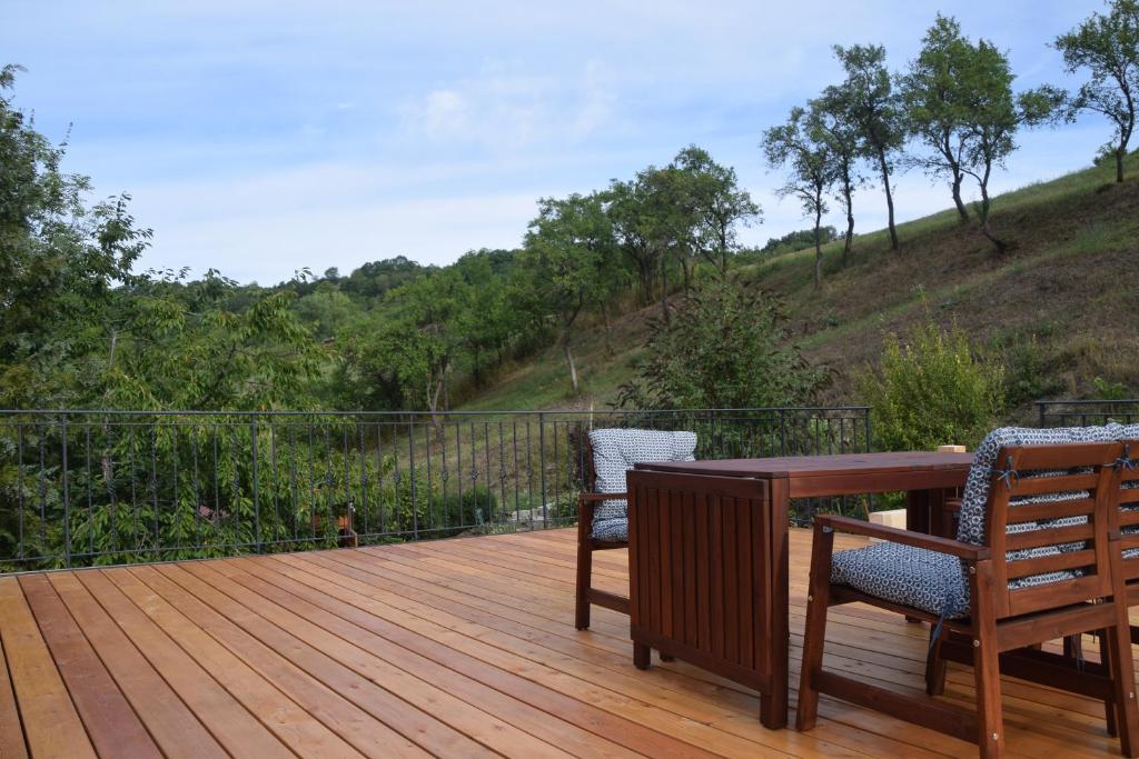 a wooden deck with two chairs and a table at Ferienwohnung Tauberzell in Adelshofen