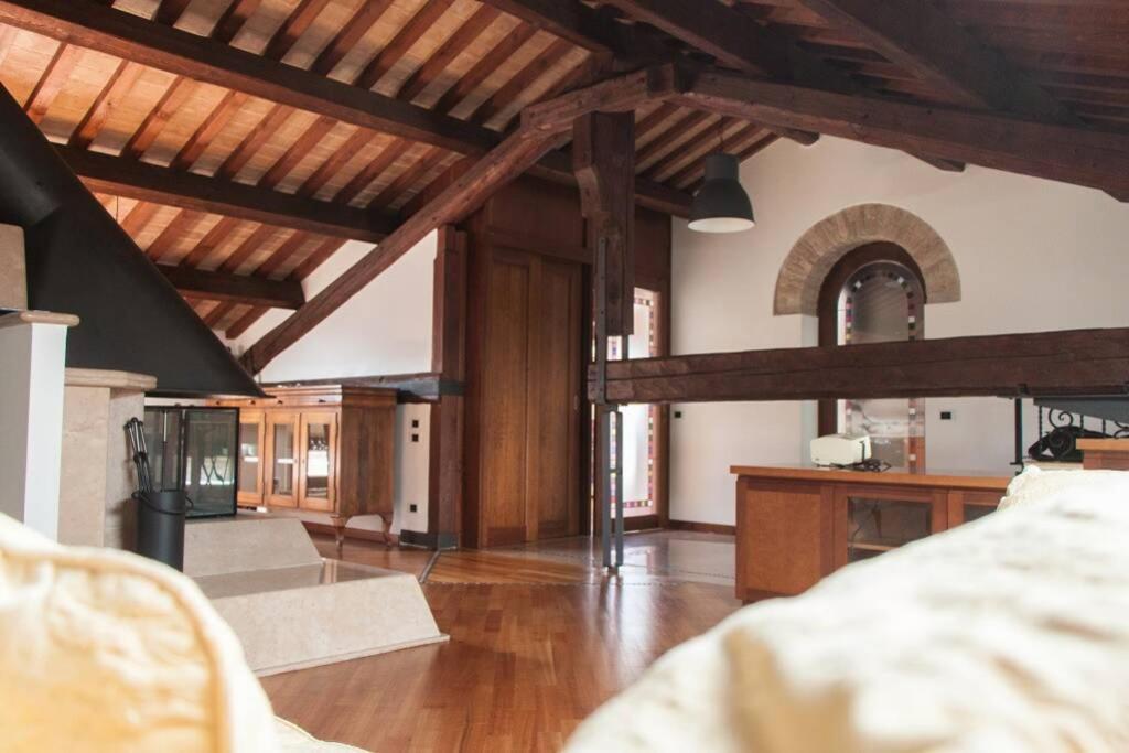 ein großes Wohnzimmer mit Holzdecken und Holzböden in der Unterkunft Attico Baggio in Bassano del Grappa