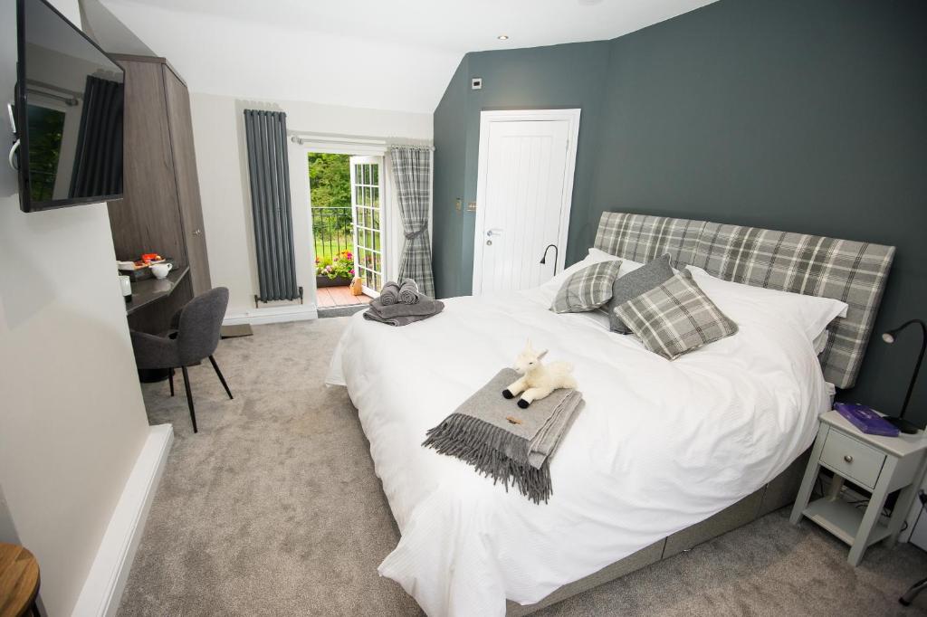 a bedroom with a white bed with a teddy bear on it at Alpaca Fold in Preston