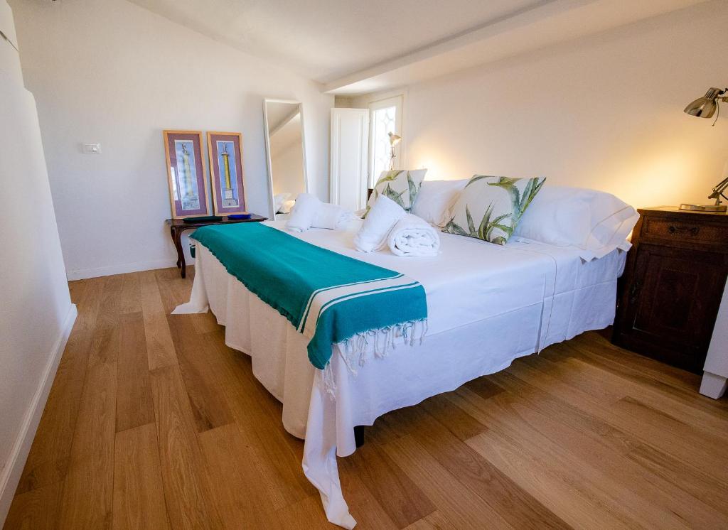 1 dormitorio con 1 cama blanca con manta verde en Acacia Firenze - Melissa, en Florencia