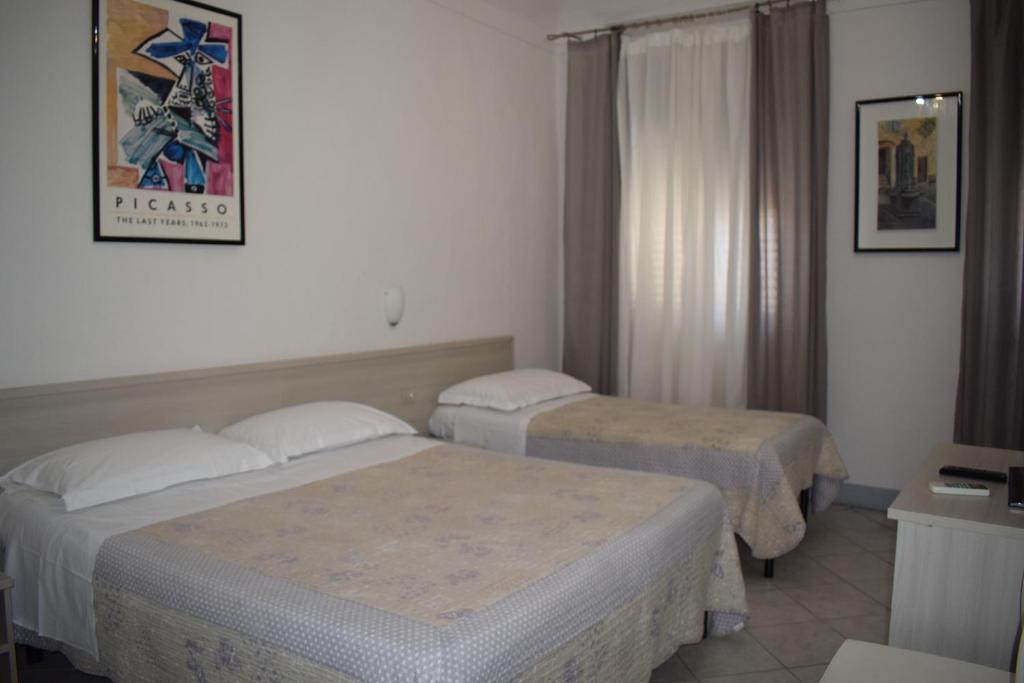 a hotel room with two beds and a window at Soggiorno Santa Reparata in Florence