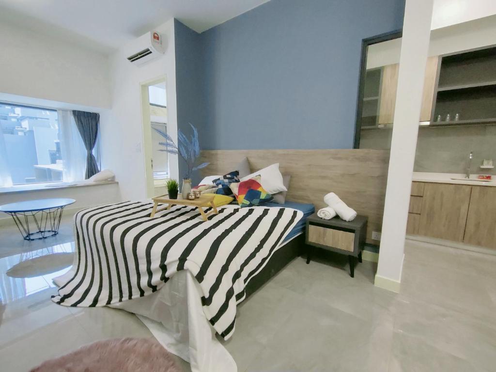 a bedroom with a bed with a black and white stripes at Imperio Residence Bathtub Studio Melacca Town-FreeParking in Melaka