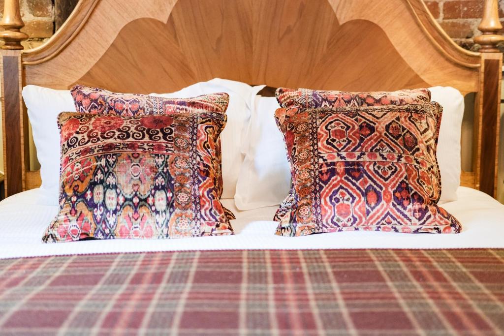 a bed with two pillows on top of it at Wykeham Arms in Winchester