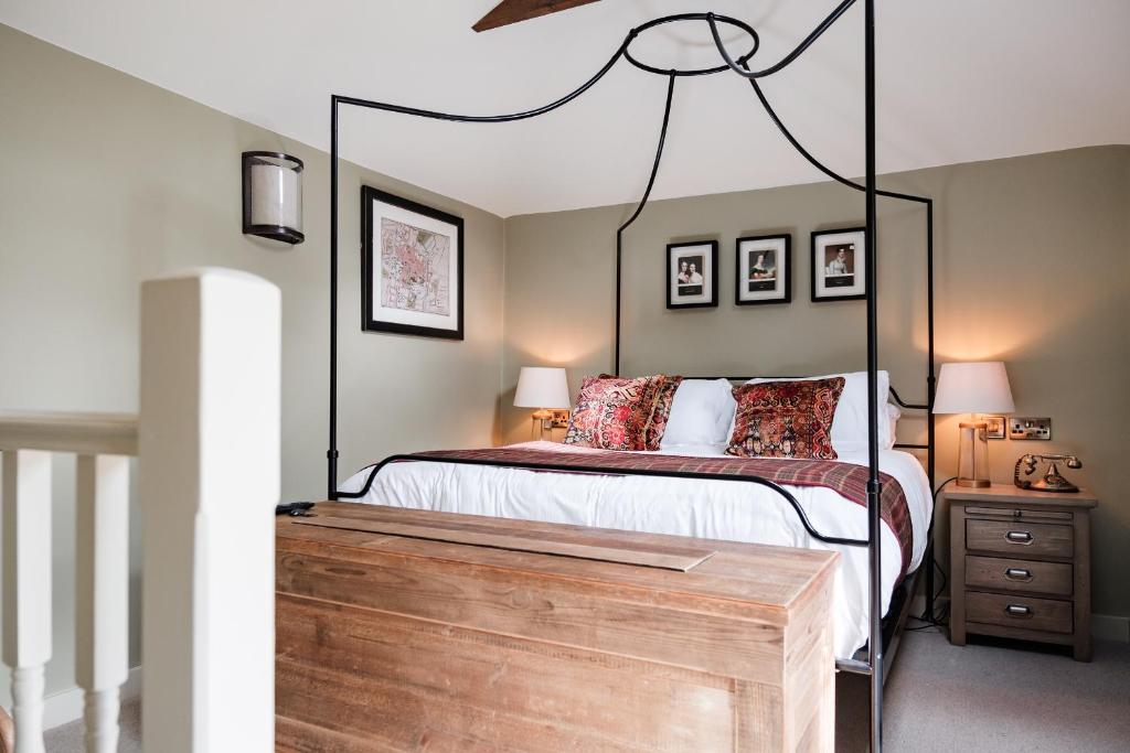 a bedroom with a large bed with a black frame at Wykeham Arms in Winchester
