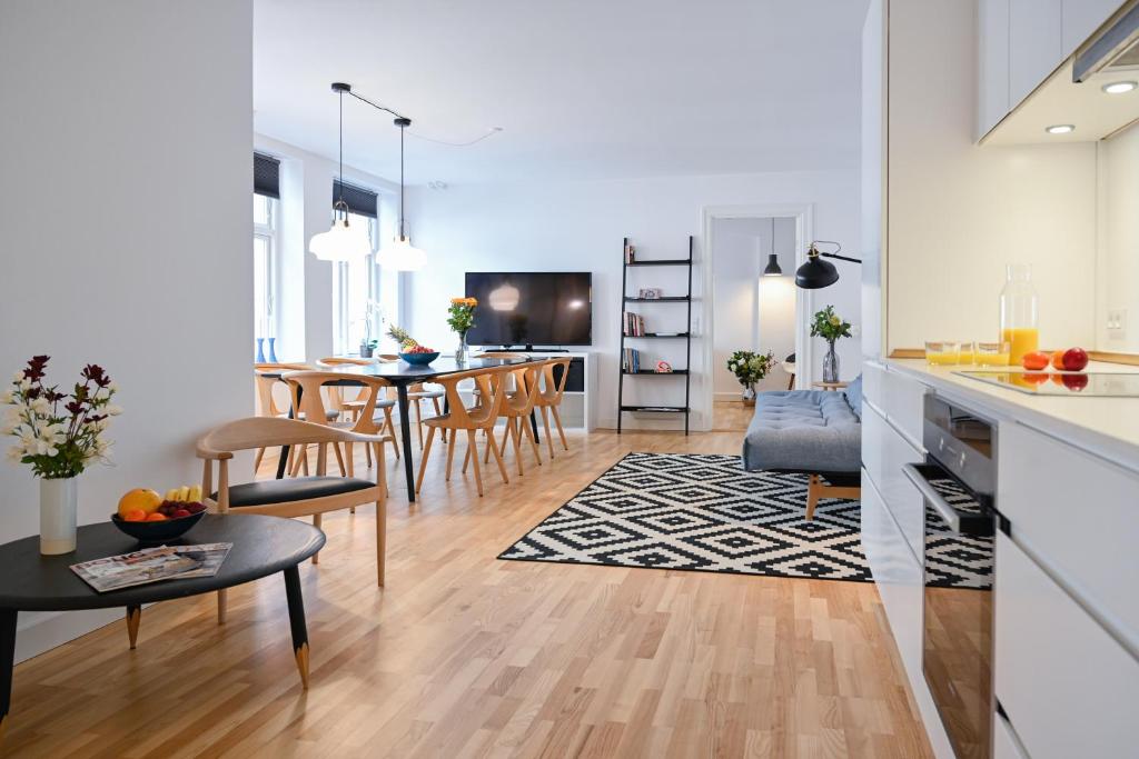 a kitchen and living room with a table and chairs at Sanders Tower - Chic Two-Bedroom Apartment In Charming Copenhagen in Copenhagen